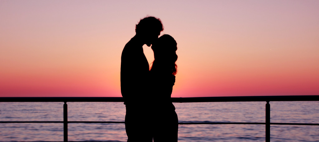 Preiswerte Singlereisen ab 50 Küssendes paar bei Sonnenuntergang am Meer